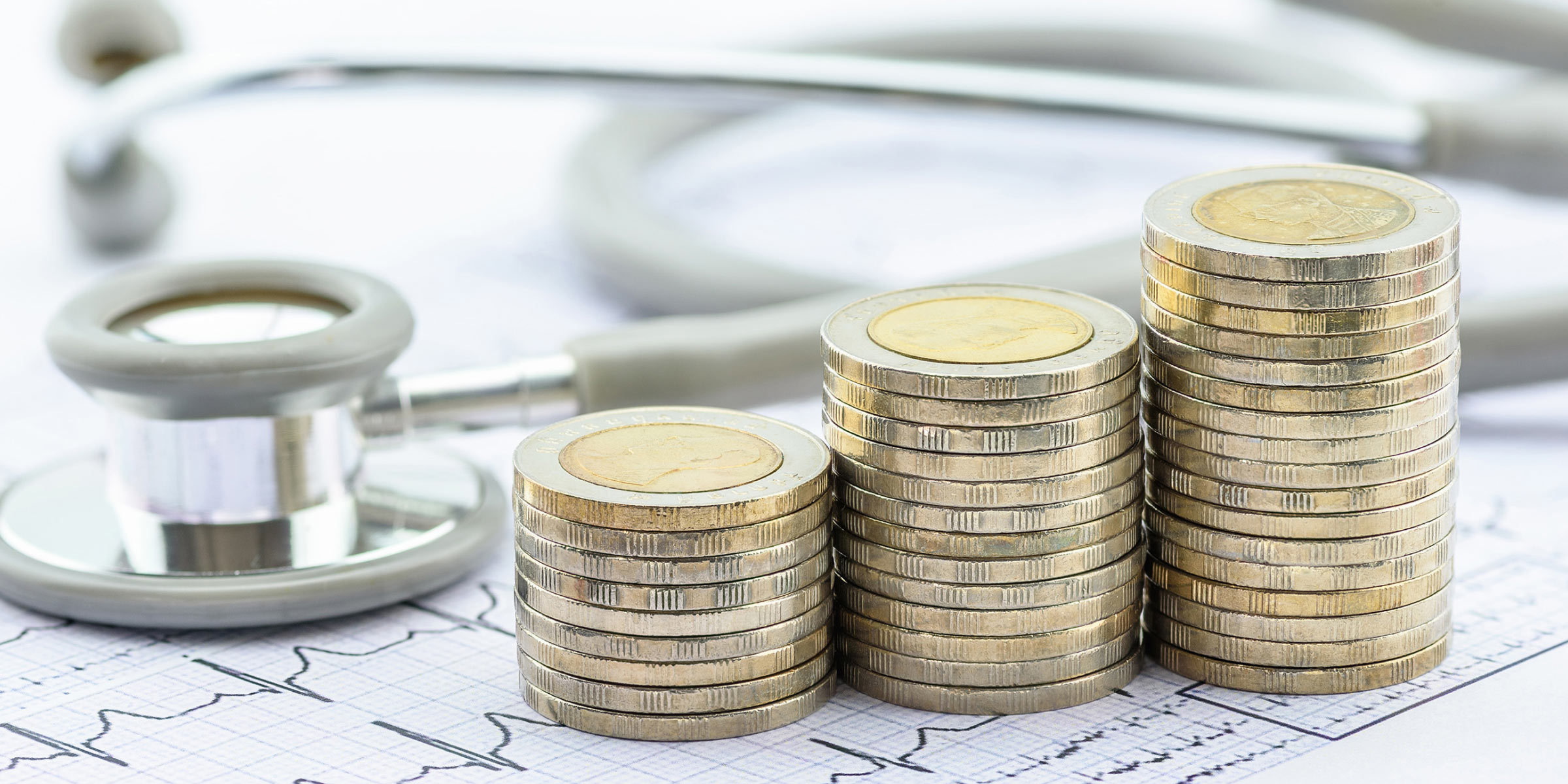 Stetoskop mit Euro Münzen, Konzeptbild Krankenhausreform und Finanzierung